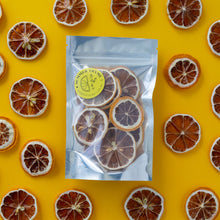 Load image into Gallery viewer, Dehydrated lemon slices arranged around a small pack of dehydrated lemons on a yellow background.
