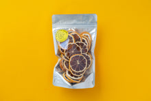 Load image into Gallery viewer, Large Summer Thyme Co. pack of dehydrated lemon citrus garnish on a yellow background.
