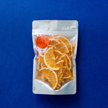 Load image into Gallery viewer, A large bag of dehydrated orange half-wheels on a contrasting dark blue background.
