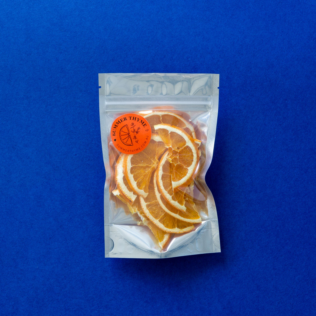 A small bag of dehydrated orange half-wheels on a contrasting dark blue background.